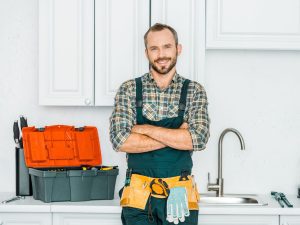 plumber standing in front of sink with arms crossed